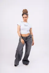 Remera blanca ajustada de jersey con lycra, con mangas cortas y estampado frontal con la frase "Break with the limits of reality" en letras cursivas negras.