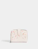 Billetera pequeña de cuerina color crema con estampado de flores pequeñas, cierre perimetral con cremallera y broche con botón a presión.