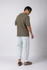 Camisa negra tejida de manga corta, con calado aireado, cuello tipo bowling y botones al tono. Diseño de corte relajado.