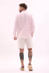 Camisa de vestir rosada de manga larga, con cuello clásico y cierre frontal con botones.