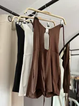 Catsuit corto con escote halter y abertura en el abdomen, con tiras finas para atar en la nuca y en la espalda.