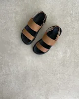 Sandalias con plataforma color marrón con textura de piel de reptil, con dos tiras anchas sobre el empeine y tira trasera ajustable.