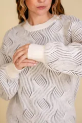 Buzo tejido color blanco con diseño en relieve de líneas verdes.