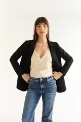 Musculosa negra con breteles finos y escote en V con detalles de encaje en el busto y la espalda.