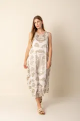 Vestido largo sin mangas con estampado floral en tonos beige y blanco.