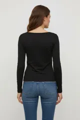 Remera negra de manga larga, confeccionada en algodón y elastano, corte ajustado al cuerpo y cuello redondo.