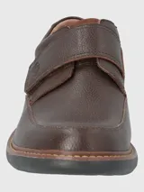 Zapato de cuero negro con ajuste de velcro, forro textil y plantilla de cuero y algodón orgánico. Suela de goma EVA con cortes para mayor flexibilidad.