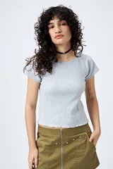 Remera gris de punto acanalado con silueta relajada y manga corta raglán. El ruedo tiene terminación ondulada.
