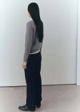 Pantalón de jean azul oscuro de corte recto, tiro medio, con cierre de cremallera y botón.