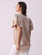 Blusa color beige de crepe, marca Batía, con cuello a la base y escote en V. Manga corta amplia con bordados.