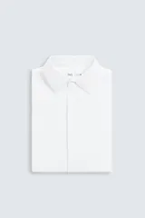 Camisa color beige de corte slim fit, confeccionada en tejido elástico que minimiza las arrugas. Tiene cuello italiano abierto, manga larga con puños abotonados y cierre frontal con botones.