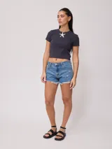 Remera blanca de algodón con elastano, corte crop top y textura acanalada.