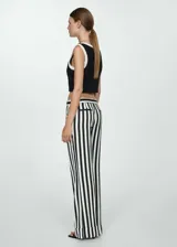 Pantalón largo de mujer con estampado de rayas verticales en blanco y negro, corte recto y bajo con vuelta.
