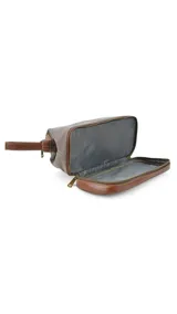 Neceser verde de tela canvas combinado con símil cuero marrón. Tiene apertura superior con cierre metálico estructural, doble bolsillo interno (uno con cierre y otro abierto con división) y base con cierre que actúa como bolsillo extra.