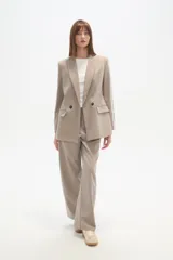 Blazer cruzado de color beige claro, con cuello solapa, dos botones frontales y bolsillos con tapa.