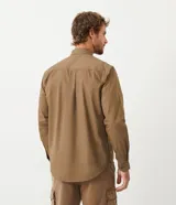 Camisa verde militar de manga larga en sarga de algodón, con cuello clásico, cierre frontal abotonado y dos bolsillos con solapa abotonada en el pecho.