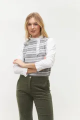 Blusa rosada con mangas largas, cuello con volados y estampado de líneas verticales.