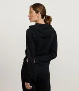 Campera deportiva color marrón, con capucha ajustable mediante cordón con lettering estampado, cierre frontal por cremallera, mangas largas con puños ajustados, bolsillo canguro y recorte en la espalda.