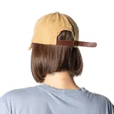 Gorra de gabardina color beige con visera curva y detalle de roturas.