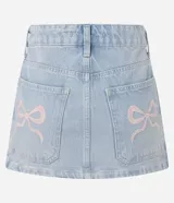 Minifalda de jean celeste con bolsillos traseros y bordado de lazo rosa en los bolsillos.