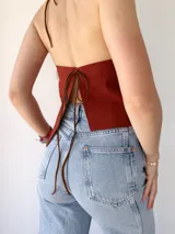 Top color terracota con cuello halter y espalda descubierta.