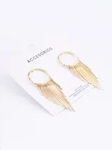 Aros colgantes dorados con forma de aro del que cuelgan múltiples flecos finos.