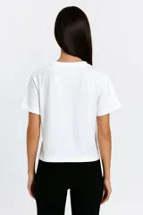 Remera blanca de algodón con cuello redondo y estampado de corazones dorados.