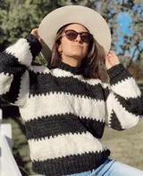 Sweater de lana merino a rayas horizontales en blanco y negro, con cuello alto y mangas largas.