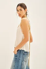 Top bretelero azul oscuro con escote en V, ribetes de puntilla a tono en escote, breteles y sisas. Presenta tachas termo adhesivas distribuidas en el frente.