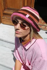 Gorro tipo bucket tejido al crochet con diseño a rayas horizontales en tonos marrón, rosa y beige.
