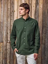 Camisa de manga larga color verde militar, confeccionada en tejido Oxford 100% algodón. Tiene cuello abotonado, cierre con botones y un bolsillo en el pecho. Corte slim fit.