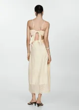 Vestido midi color crema con bordado calado, breteles finos, escote cuadrado, corte evasé, cut-out en la cintura y cierre lateral con cremallera.