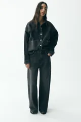 Pantalón de jean negro con efecto lavado, corte wide leg y tiro alto.