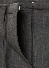 Pantalón de vestir azul marino con finas rayas verticales blancas, corte recto, tiro medio, lazo a la cintura y cierre de gancho y cremallera.
