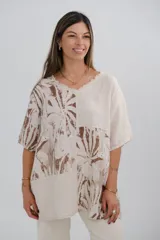 Blusa beige con estampado de hojas marrones, cuello en V y corte holgado.
