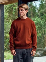 Sweater de punto color marrón ladrillo, de manga larga y cuello redondo.