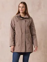 Campera impermeable color beige, marca Weatherproof, con capucha desmontable, cierre central oculto con botones a presión, bolsillos laterales con cierre y corte a la altura de la cadera.