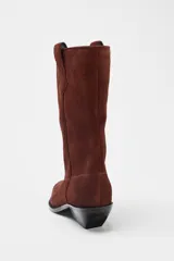 Botín de mujer estilo cowboy color marrón de serraje con puntera fina y tiradores laterales. Tacón de 5 cm.