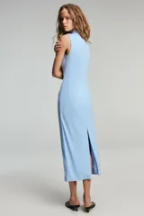 Vestido midi color blanco hueso, sin mangas, con cuello alto y detalle de drapeado fruncido en el lateral izquierdo del torso.