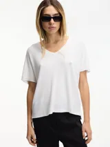Remera blanca de punto con escote en V y pespuntes a contratono.