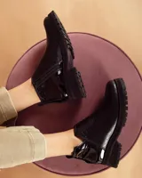 Botines negros de cuero con elástico lateral, detalle charol en el talón y suela track.