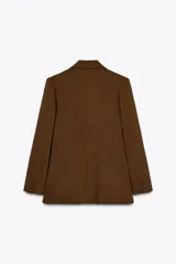 Blazer marrón de cuello solapa y manga larga. Bolsillos con solapa en delantero y cierre frontal cruzado con botones forrados.