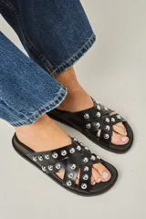 Sandalias negras de cuero vacuno con tachas redondas plateadas, suela anatómica de goma.