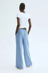 Pantalón de corte recto y holgado en tejido de mezcla de lino color celeste. Cuenta con cintura elástica con cordón de ajuste, bolsillos laterales y bolsillos traseros insertados.