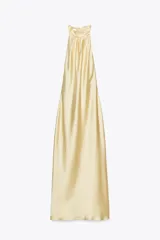 Vestido midi de satén color amarillo pálido, con cuello halter y espalda descubierta.