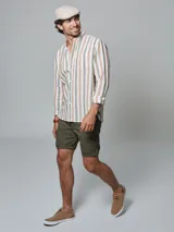 Bermuda color beige con cinturón, corte regular fit, dos bolsillos delanteros, dos traseros, un bolsillo relojero y botamanga con presilla. Aplique de badana.