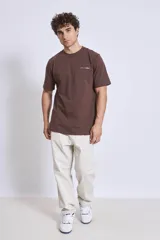 Remera de manga corta color marrón oscuro con cuello redondo y un pequeño texto bordado en blanco en el pecho.