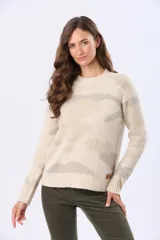 Buzo tejido de cuello redondo, color beige con estampado abstracto en tonos rosados y grises. Tiene mangas largas con puños acanalados y un pequeño parche de cuero sintético en el dobladillo.