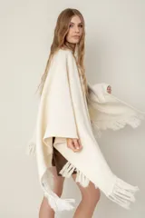 Ruana de punto color negro, modelo Esteña, con diseño abierto y terminación de flecos en los bordes.