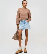 Sweater de punto color beige claro, con textura de rayas horizontales formadas por puntos calados. Presenta cuello redondo, mangas largas y puños y ruedo acanalados.